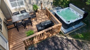 A deck with a hot tub, outdoor seating, and a small table. - Hot Tub ~ Luxury Landing (Tobyhanna)