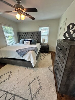 A bedroom with a bed, a ceiling fan, a nightstand, a dresser, and a rug. - Pet friendly High Point Terrace Gem-Backyard Oasis (Memphis)