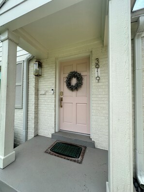 A house with a pink door, a wreath, a mailbox, and a number sign. - Pet friendly High Point Terrace Gem-Backyard Oasis (Memphis)