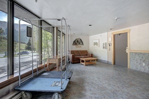 A lobby with a wheelchair ramp, a couch, a coffee table, a door, and a view of the outdoors. - Pet Friendly Hotel Room in Central Copper MTN! (Frisco)