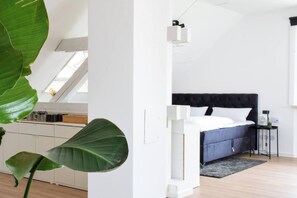 A modern bedroom with a bed, bedside table, and a large window.