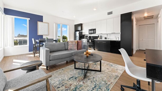 Eine moderne Wohnung mit Wohnzimmer, Küche und Essbereich.