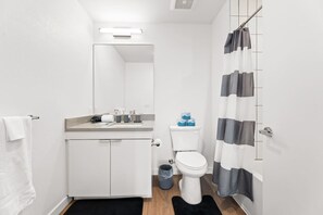 A compact bathroom with a toilet, sink, and mirror.