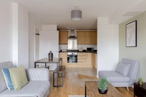 Ein modernes Apartment mit Wohnzimmer, Essbereich und Küche.