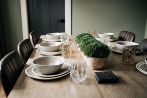 A dining table set with plates, bowls, glasses, and a centerpiece. - 2 king beds w/private baths •firepit •walk to town and Lake Charlevoix (Boyne City)