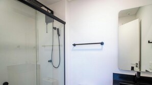 A modern bathroom with a glass shower enclosure, a towel rack, and a toilet. - Studio 500m fr/ Vila Germanica, Blumenau Pin1907 (Blumenau)