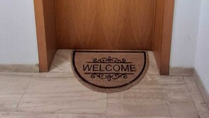 Uma porta de madeira com um tapete de boas-vindas.