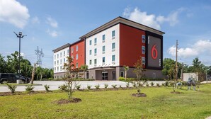 Ein modernes Hotel mit roter und weißer Fassade, mehreren Stockwerken und einem sichtbaren Eingang.