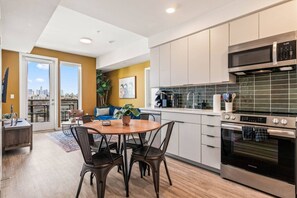 Une cuisine moderne avec un coin repas, une grande fenêtre et une vue sur la ville.