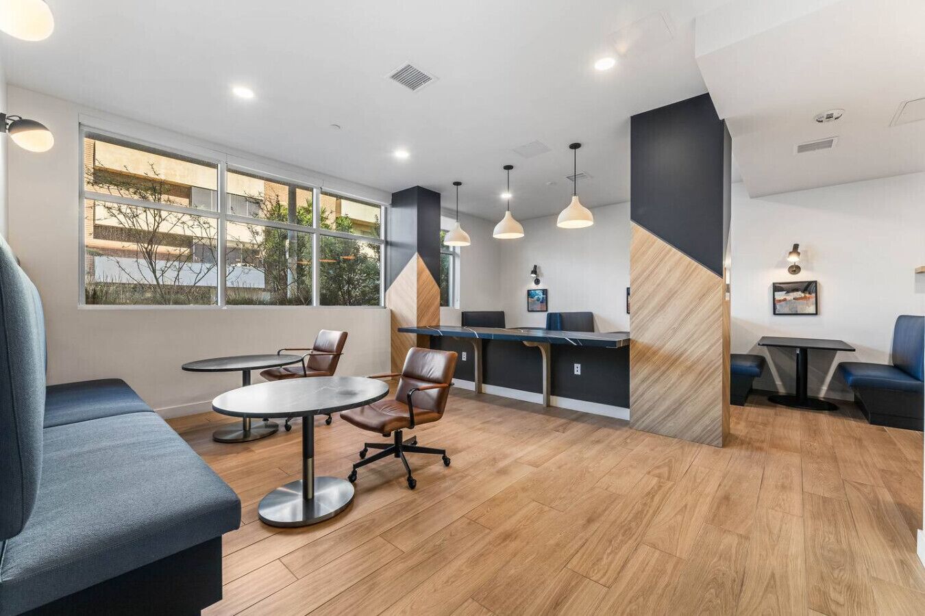 Un intérieur moderne comprenant un coin repas, des sièges et une vue dégagée grâce à de grandes fenêtres.