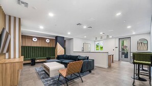 A modern interior with a sofa, a chair, a small table, a reception desk, and a door.