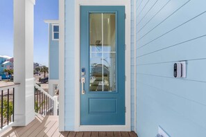 Una puerta azul con un panel de vidrio, un buzón y una pequeña ventana lateral.