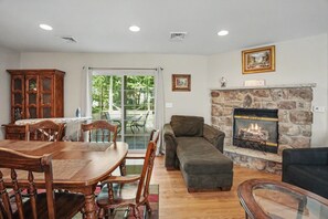 A dining area with a wooden table and chairs, a sofa, and a fireplace. - Minutes to Kalahari - 4 Bedrooms - Game Room (Pocono Summit)