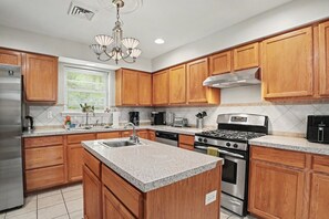 A modern kitchen with wooden cabinets, stainless steel appliances, and a granite countertop. - Minutes to Kalahari - 4 Bedrooms - Game Room (Pocono Summit)