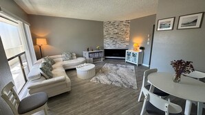 A living room with a sofa, coffee table, and a fireplace. - Magical Monterey Carmel Pebble Beach travel, family and pet friendly whole Condo (Monterey)