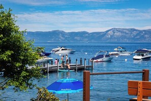 Ein Yachthafen mit vertäuten Booten, eine hölzerne Bank und ein freier Blick auf die Berge im Hintergrund.