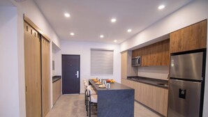 Eine moderne Küche mit Holzausstattung, einem Edelstahlkühlschrank und einer eingebauten Mikrowelle.
