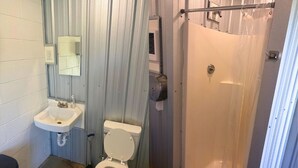 Un baño con inodoro, lavamanos y ducha.