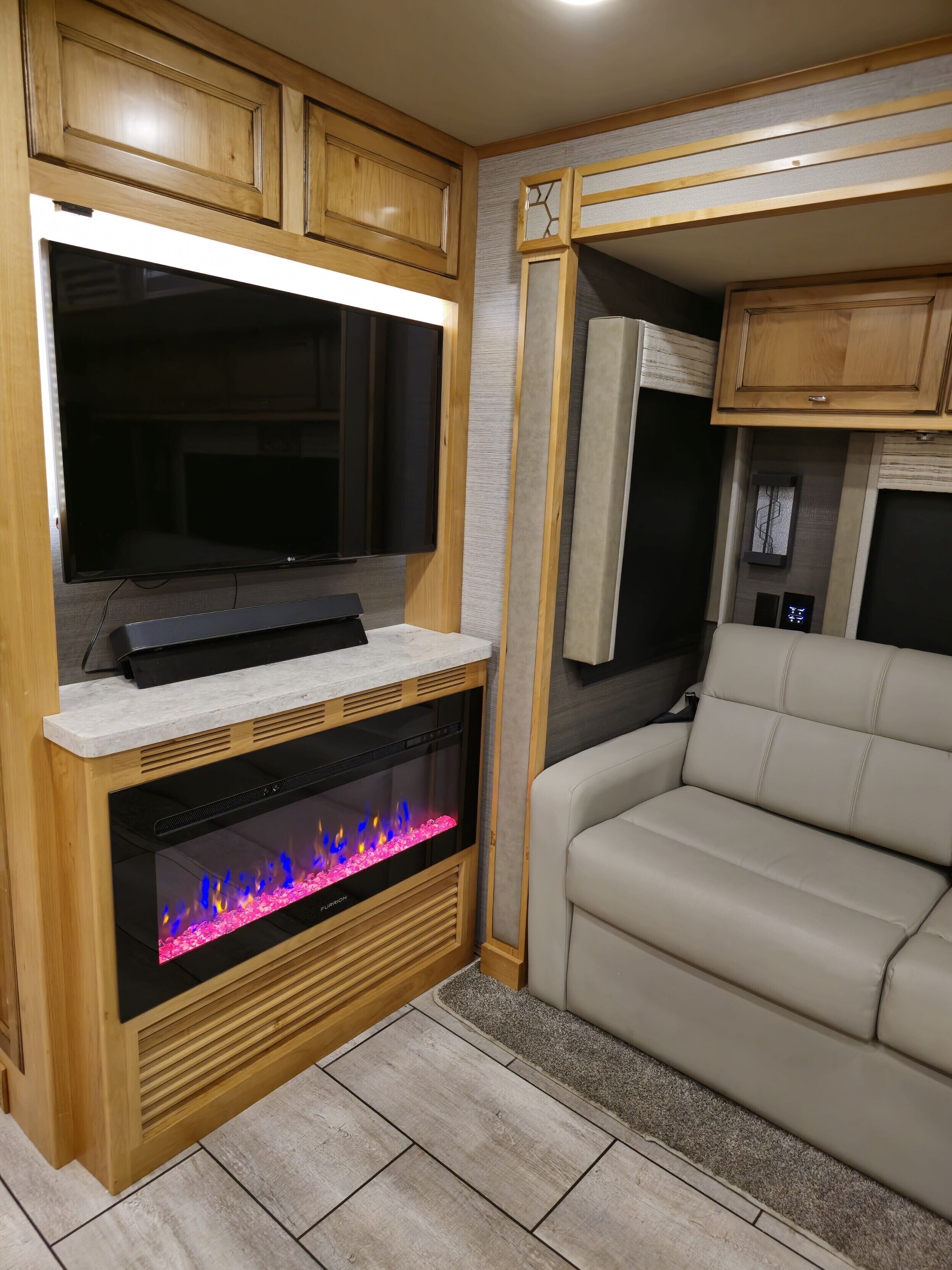 A living area with a fireplace, a television, and a sofa.