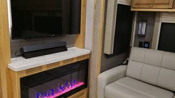 A living area with a fireplace, a television, and a sofa.
