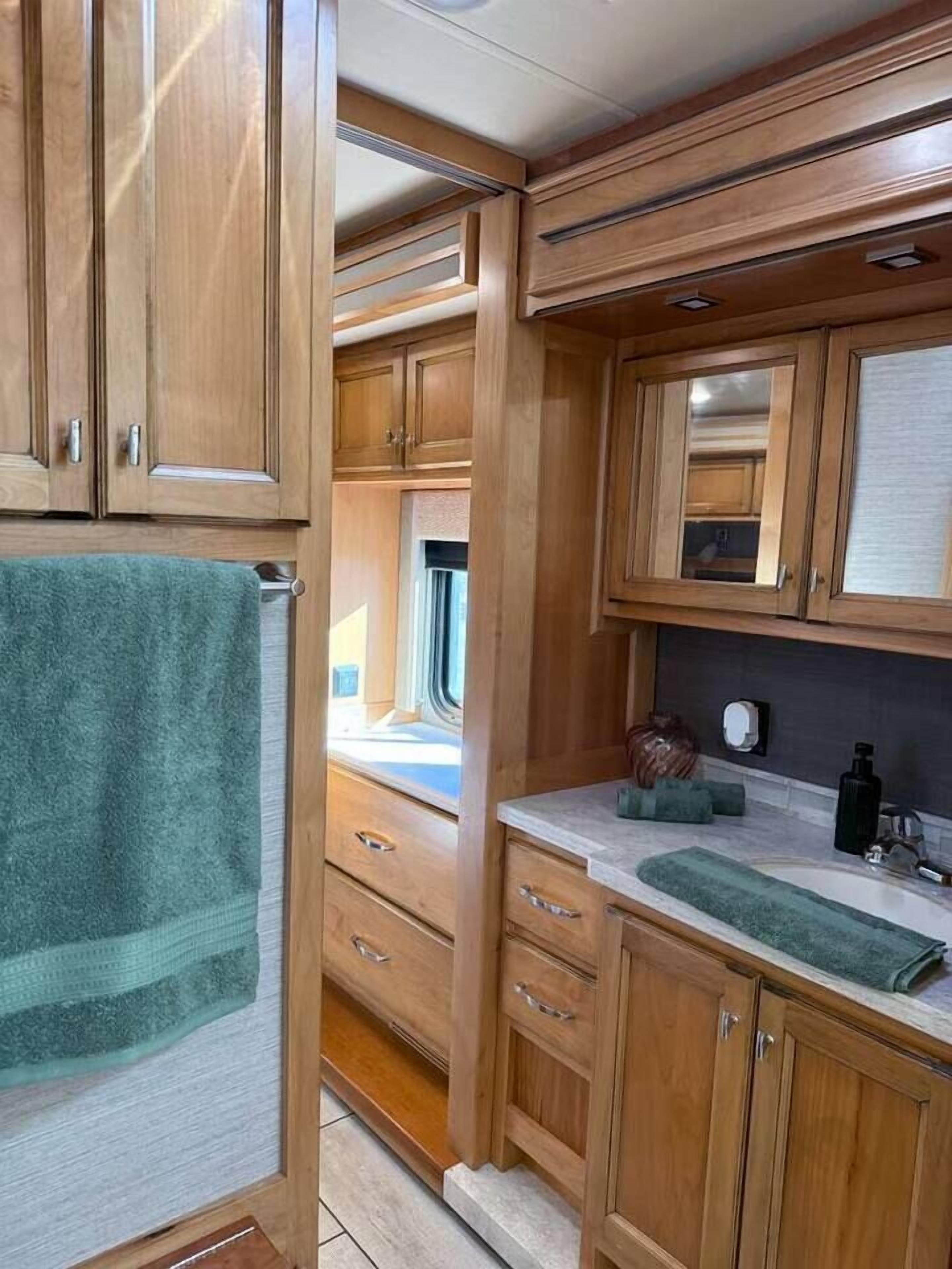 A compact kitchen with wooden cabinets, a countertop, and a window.