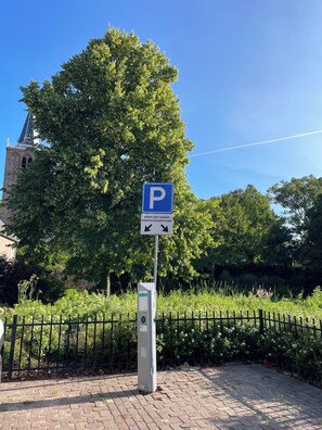 A parking sign with a P symbol, a directional sign, and a parking meter. - Newly renovated vacation rental between Amsterdam, the North Sea, the dunes, and Egmond (Castricum)