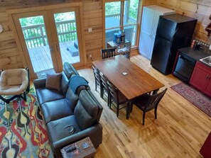 Un intérieur en bois comprenant un canapé, une table à manger, des chaises et un coin cuisine.