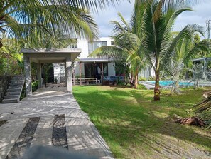 A pathway leading to a covered area with a pool and a grassy yard. - Serene 3-bedroom Villa With Private Pool in Roches Noires (Roches Noires)