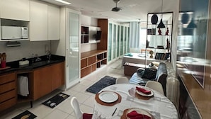 A modern kitchen with a dining area, a sofa, and a TV. - Carioca Corner (Rio de Janeiro)