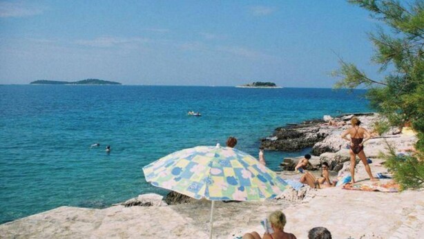 A beach with people, a rocky shoreline, and a clear view of the sea. - Two bedroom apartment (Rogoznica)
