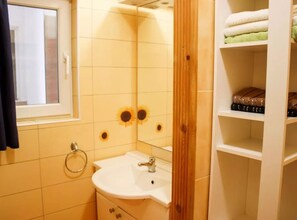 Ein Badezimmer mit Waschbecken, Spiegel und Handtuchhalter.