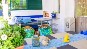 A dining area with a table set for two, chairs, a small table, and a bench. - two bedroom apartment Mirjam (Zadar)