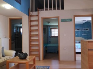 Ein Zimmer mit einem Holztisch, einer Couch, einer Leiter und einem Schild an der Wand.