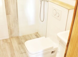 A bathroom with a toilet, a shower, and a sink. - one bedroom apartment Olea (Podgora)