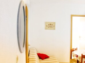 Ein Zimmer mit einem Bett, einem kleinen Tisch und einem Sessel.