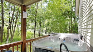 A hot tub on a wooden deck with a view of trees. - The Fairway Retreat (Oakland)