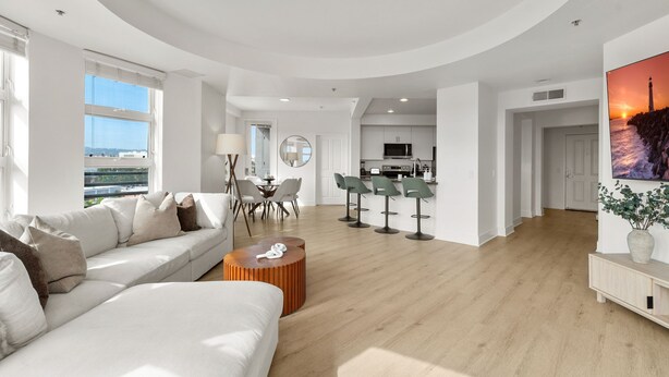 Un salon moderne comprenant un canapé, une table basse et un coin repas avec des chaises et une table.