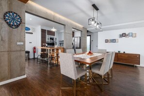 A modern kitchen with a dining area, a dartboard, and a sign indicating Wi-Fi availability. - Table Top by Azorean Living (Ponta Delgada, São Miguel)