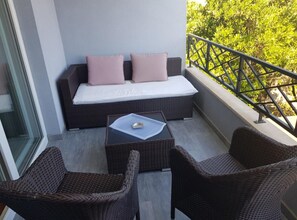 A balcony with a sofa, two wicker chairs, and a small table with a tray. - Studio apartment (288) (Orebic)