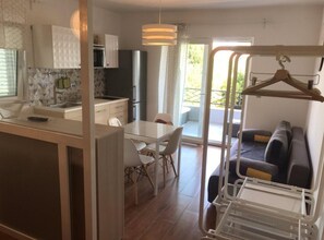 A modern kitchen with a dining area, a sofa, and a view of the outdoors. - Studio apartment (288) (Orebic)