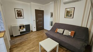 A living room with a grey sofa, a white coffee table, and a wooden floor. - One bedroom apartment (702) (Orebic)