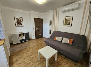 A living room with a grey sofa, a white coffee table, and a wooden floor. - One bedroom apartment (702) (Orebic)