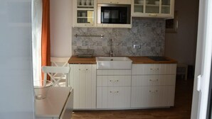 A compact kitchen with white cabinets, a microwave, and a sink. - One bedroom apartment (702) (Orebic)