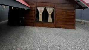 Um edifício de madeira com telhado inclinado e chão de cascalho.