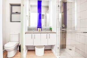 Ein modernes Badezimmer mit Toilette, Waschbecken und Dusche.