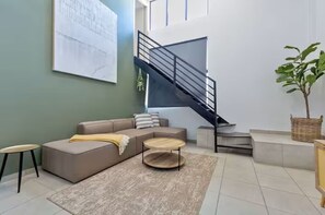 Ein modernes Wohnzimmer mit einer Couch, einem Couchtisch und einer Treppe.