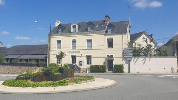 A building with a sign reading 'L'Espérance' at the entrance, a roundabout, and a stone wall with greenery. - L Espérance  (Vitré)