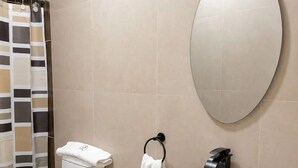 A modern bathroom with a toilet, bidet, sink, and a large mirror.