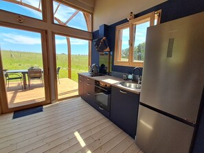 A kitchen with a refrigerator, sink, and window.