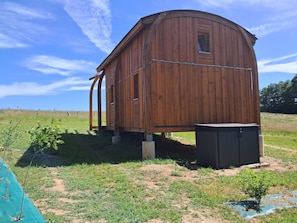 A wooden structure with a curved roof, a small window, and a door.